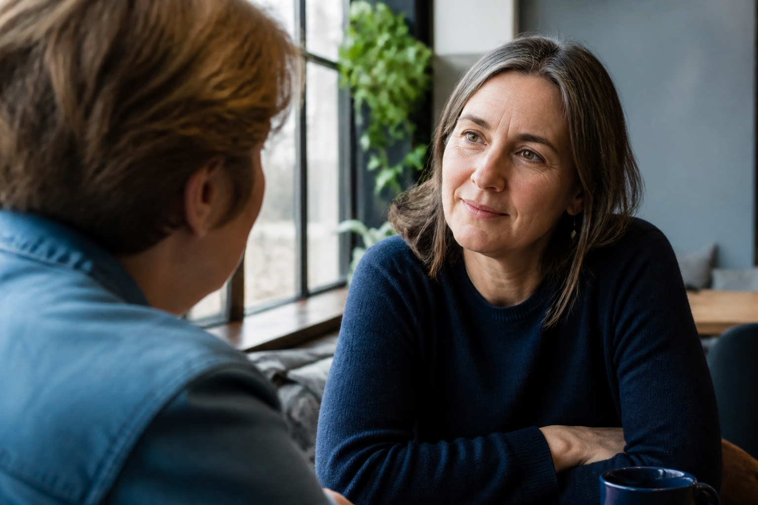 Two adults in a calm conversation, one listening attentively